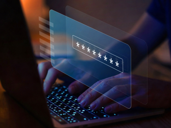 Hand gibt auf Laptop Passwort ein